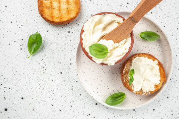 Sandwiches with tasty cream cheese and fresh basil leaves on a light background. banner, menu,...