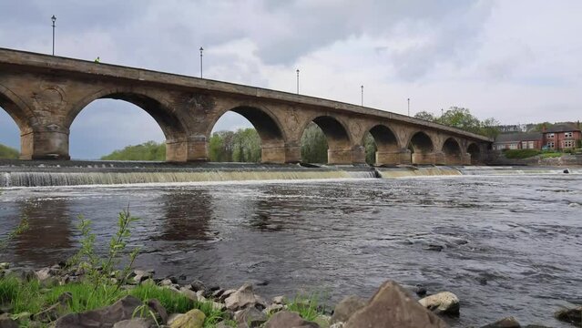 Old Stone Bridge With Arches Across the River in Cloudy Weather