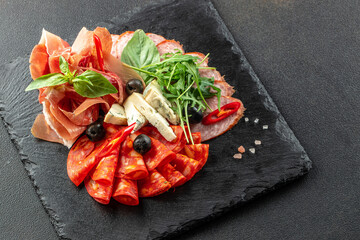 meat appetizer traditional Spanish tapas ham, salami and goat cheese