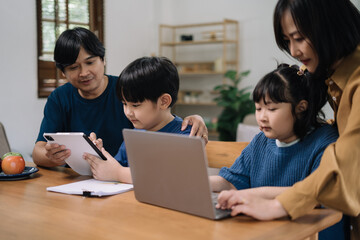 Obraz premium work from home education concept and family at home sitting at desk business woman working on internet in laptop child writing in notebook
