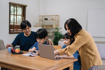 work from home education concept and family at home sitting at desk business woman working on internet in laptop child writing in notebook