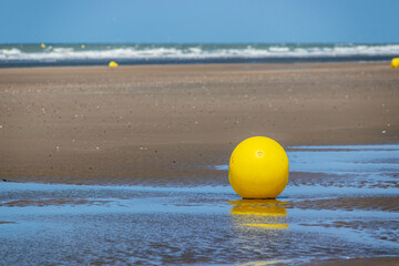 eine kleine gelbe boje am strand von dünkirchen
