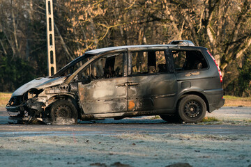 Obraz na płótnie Canvas A car burnt out in a fire in an abandoned parking lot.