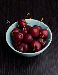 Cherry in a bowl on a wood background