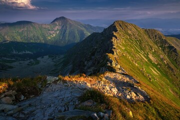Summer hiking in the mountains with massive rocks, dramatic skies and majestic mountains. Mountain sunset in Slovakia mountain - Rohace, Mountain hiking holiday Western Tatras.