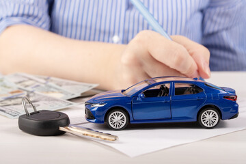 contract signing process during a car purchase, a woman in the office fills out an agreement of a...