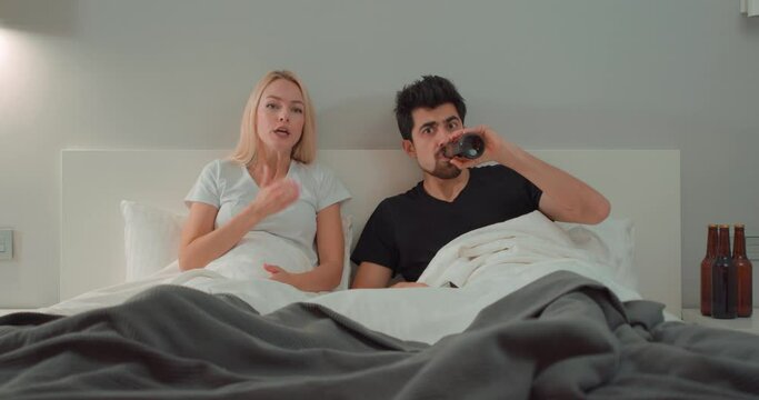 upset furious angry woman scolding her husband for watching football, drinking beer. misunderstanding, laziness concept. young female regretted that she married a mediocre and drunk man, she left room