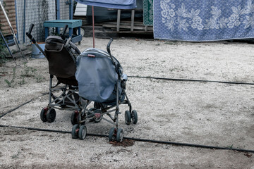 Fototapeta na wymiar Old broken baby carriages. Baby carriages abandoned on the street