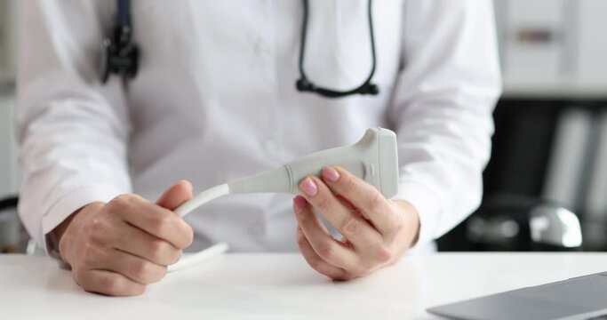 The doctor holds in his hands a probe for ultrasound close-up. Medical equipment for diagnostics and examination of internal organs