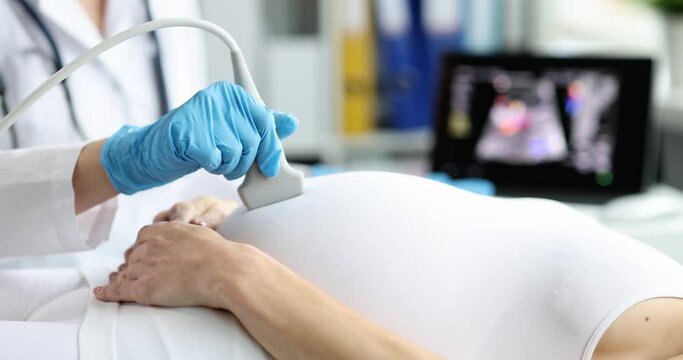 The doctor makes an ultrasound scan of a pregnant woman close-up. Medical equipment, fetal health diagnostics