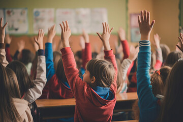 Students raising their hands in class at the elementary school, back view
