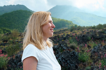Hiking on tallest volcano in Continental Europe - Etna. Smiling young woman enjoying the air on...