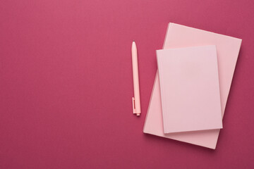 Notebooks with stationery on color background, top view