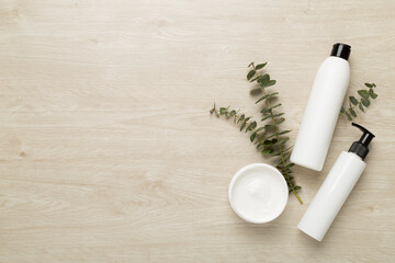 Professional hair care products with comb on wooden background, top view