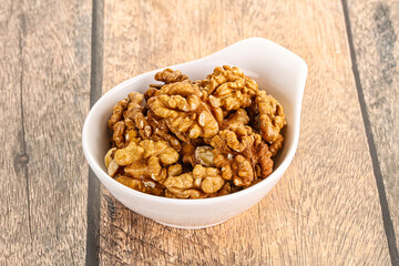 Cracked unshelled walnut in the bowl