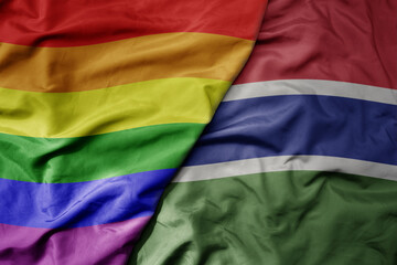 big waving realistic national colorful flag of gambia and rainbow gay pride flag .