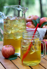 Apple juice in glass and pitcher with fresh apples