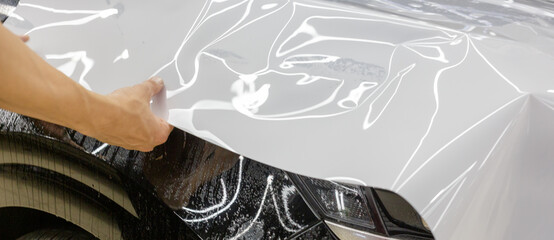 The process of installing PPF on the hood of the car. Anti-gravity protection. PFF is installed. Car wrapping. 