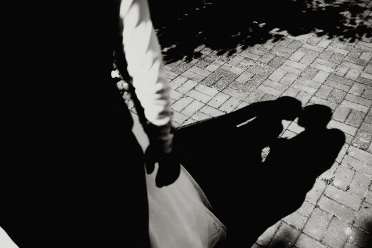 The bride and groom walk after the wedding ceremony. black and white photo, shadow on the tile from the bride and groom