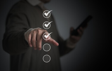 Performance checklist concept : businessman using finger with mobile phone for questionnaire,...