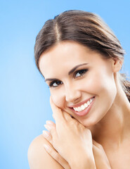 Portrait of beautiful young happy smiling woman, over blue background