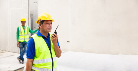 Radio walkie talkie. Asian senior man professional engineering working at precast concrete wall factory. Engineering worker in safety hardhat at factory industrial facilities