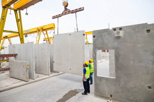 Reinforced concrete structures. Man construction worker control large crane for placing precast concrete panels at Heavy Industry Manufacturing Factory