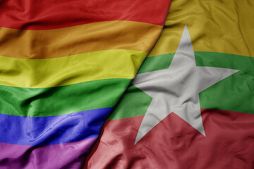 Fototapeta premium big waving realistic national colorful flag of myanmar and rainbow gay pride flag .