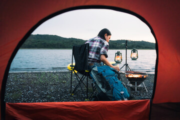 traveler, beautiful asian traveler Camp by the river, with luggage, bonfires and kayaks. Evening camping activities The atmosphere of camping in the evening of Asian women