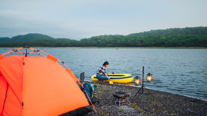 traveler, beautiful asian traveler Camp by the river, with luggage, bonfires and kayaks. Evening camping activities The atmosphere of camping in the evening of Asian women