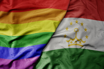 Fototapeta premium big waving realistic national colorful flag of tajikistan and rainbow gay pride flag .