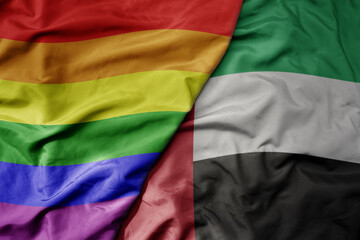 Fototapeta premium big waving realistic national colorful flag of united arab emirates and rainbow gay pride flag .