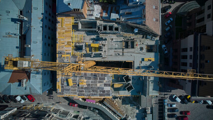 The yellow construction crane is working. View from above