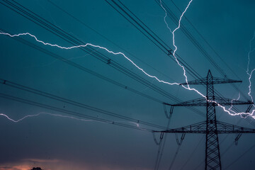 Ein Gewitter und Blitze über den Stromleitungen und Bäumen 