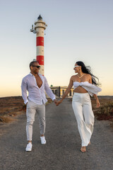Pareja paseando por la carretera del faro