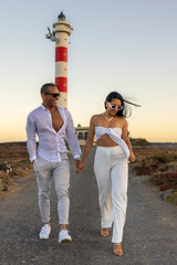 Pareja paseando por la carretera del faro