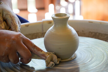 Obraz na płótnie Canvas Woman's hands making ceramic cup on potter's wheel 