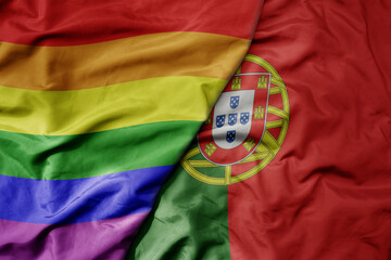 big waving realistic national colorful flag of portugal and rainbow gay pride flag .