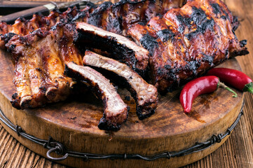 Barbecue veal spare ribs with hot honey chili served as close-up on a rustic old wooden board