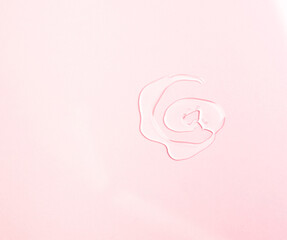 Sample of a transparent gel on a pink background. Texture of liquid cosmetic gel.