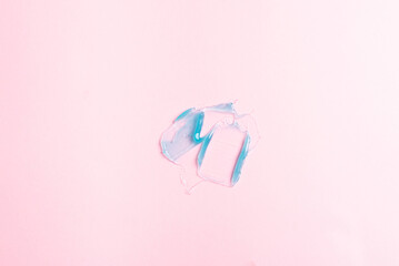 Cosmetic sample texture. Smears of transparent blue liquid cosmetics on a pink background