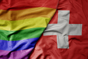 big waving realistic national colorful flag of switzerland and rainbow gay pride flag .