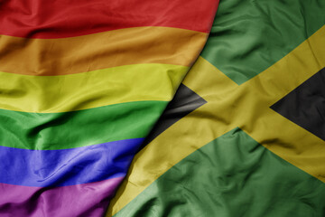 big waving realistic national colorful flag of jamaica and rainbow gay pride flag .
