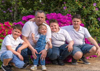 .Portrait of a large, cheerful family on a floral background. Happy dad and four sons of different...