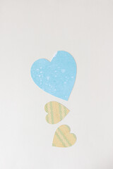 big blue heart with slight chip on its shoulder and two smaller hearts playing unawares below