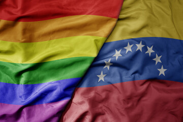 big waving realistic national colorful flag of venezuela and rainbow gay pride flag .