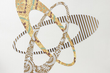 overlapping ovoid shapes machine-cut from scrapbooking paper and arranged on blank paper