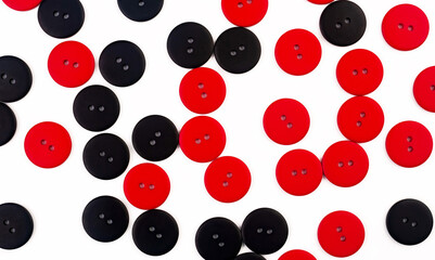 Plastic round red and black buttons on a white background