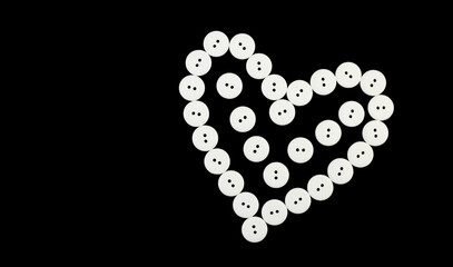 Black background with heart from white buttons