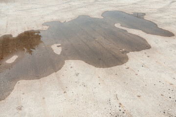 water puddle on old concrete surface outdoors in mid day sun